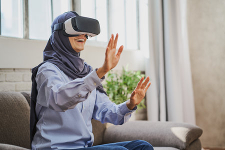 Muslim woman exploring new virtual worlds with a VR headsetの写真素材