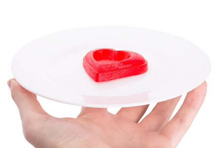 red heart on the plate and in hand.の写真素材