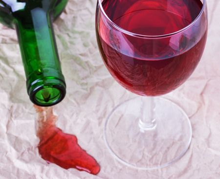 glass of red wine with a bottle on the newspaper.の写真素材