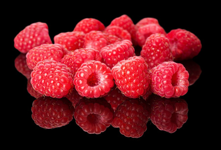 juicy raspberries on the black background.