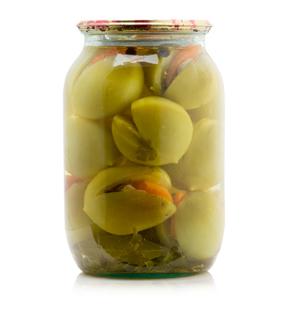Marinated green tomatoes canned in glass jar isolated on the white background.の写真素材