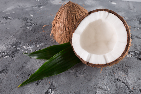 coconuts with leaves on the grey stone background.の写真素材