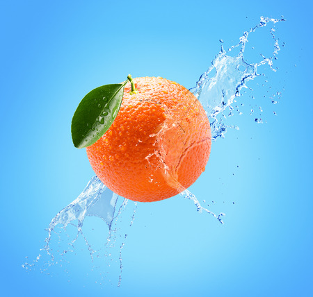 orange in water splash on a blue background.の写真素材