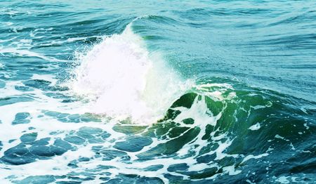 Big green wave breaks in ocean