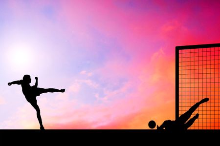 Silhouettes of footballers on the sunset skyの写真素材