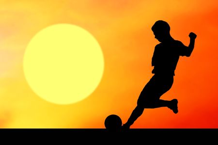 Silhouettes of footballers on the sunset skyの写真素材