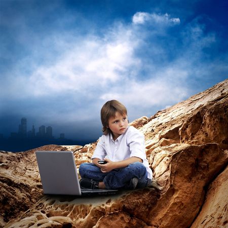 Child with laptop on the mauntain under sky with cloudsの写真素材