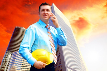Young architect wearing a protective helmet standing on the building backgroundの写真素材