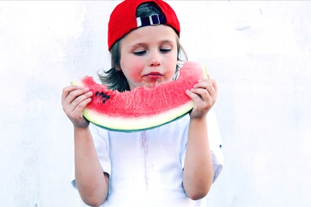 Child with part of watermelon, isolated on the white backgroundの写真素材