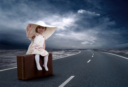 Little girl waiting on the road with her vintage baggageの写真素材