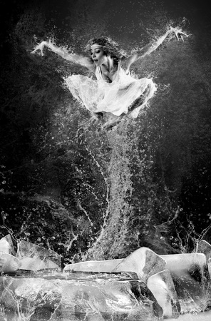 Jump of ballerina on the ice dancepool around splashes of water dropsの写真素材