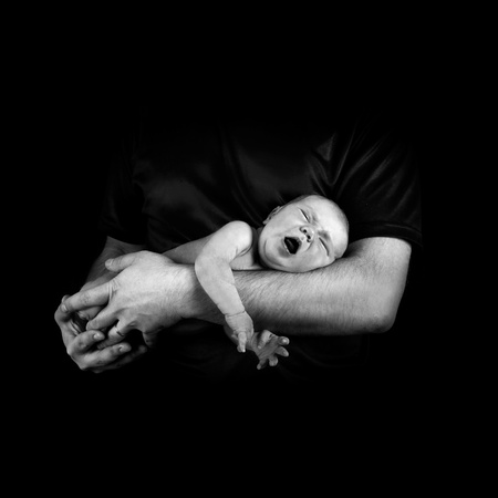 Newborn baby on the fathers hands