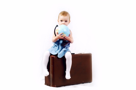 A little girl with globe and old baggageの写真素材