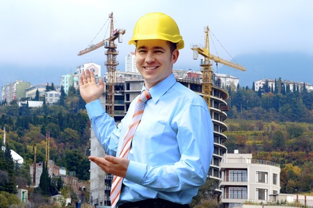 Young architect wearing a protective helmet standing on the mountains building outdoor backgroundの写真素材