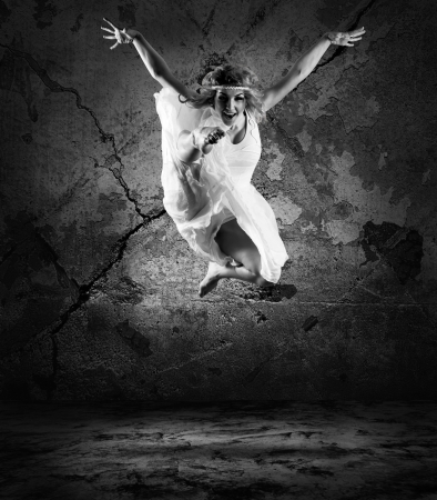 Woman dancer jump posing on background の写真素材