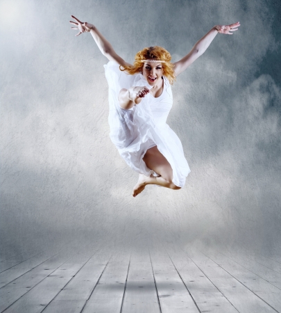 Woman dancer seating posing on backgroundの写真素材