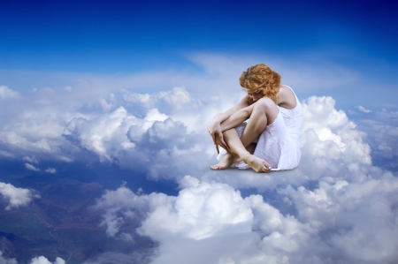 Ballerina seating on the sky cloudsの写真素材