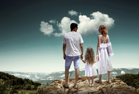 Family stay on the top of mountain, looking on the beautiful view.の写真素材