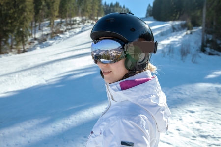 Woman in goggles and helmet stay on the snowの写真素材