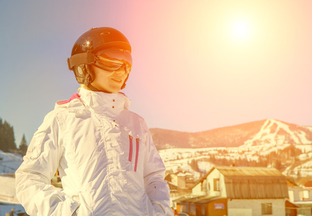 Woman wearing a helmet and glasses on the background of snow winter and mounts.の写真素材