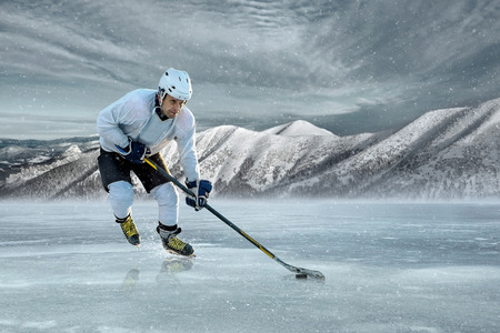 Ice hockey player on the ice in mountains