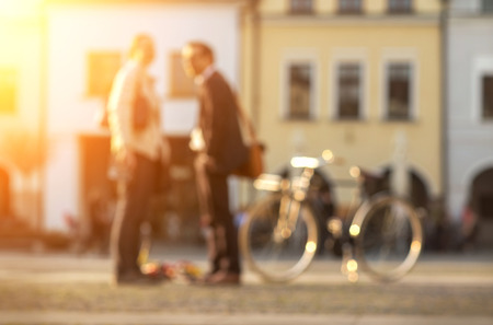 Blurred Couple with bicycle stay on the street at sunny day.