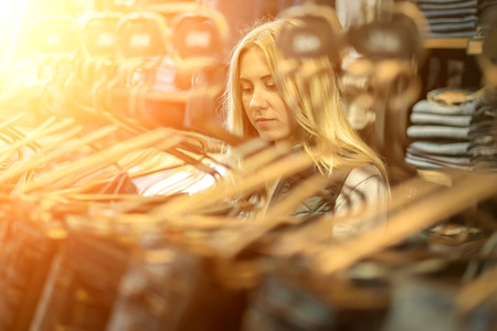 Beautiful blonde female looking jeans in the boutiqueの写真素材