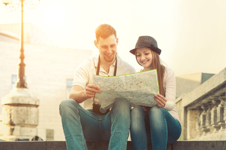 Touristic couple looking at map on the city streetの写真素材