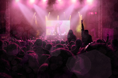 Rock concert, silhouettes of happy people raising up hands