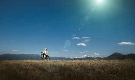 Father and son on bicycle under sunlight.の写真素材