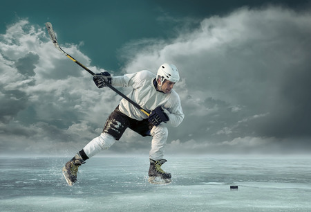 Ice hockey player in action outdoor around mountainsの写真素材