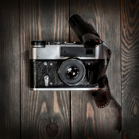 Retro film photo camera on the wooden background.の写真素材