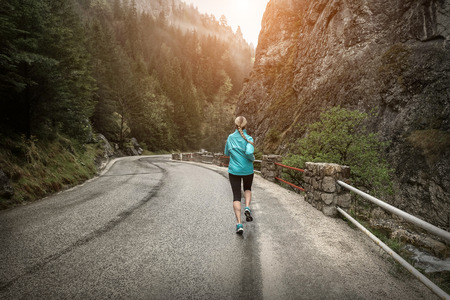 Running on the road around mountains under snowly rain.