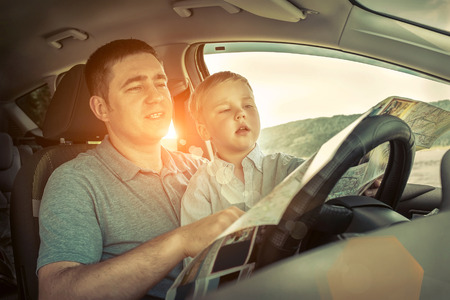 Father and son looking on map in carの写真素材