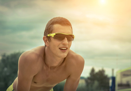 Beach Volleyball player in sunglasses under sunlight. Dynamic sport action outdoor.の写真素材