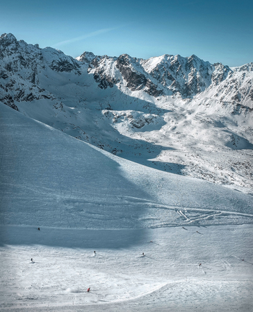 Nice mountains view at sunny day with skiers under blue sky with sun light at winter time.の写真素材