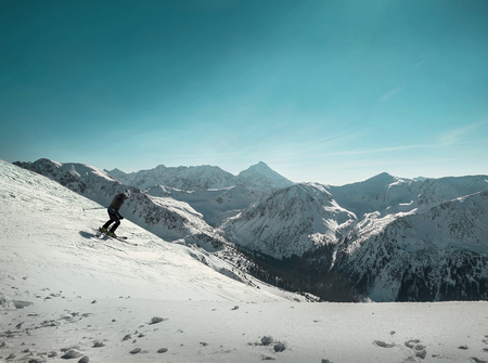 Nice mountains view at sunny day with skiers under blue sky with sun light at winter time.の写真素材