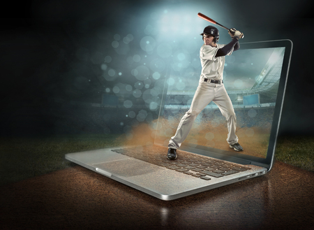 Caucassian baseball Players in dynamic action with ball in a professional sport game play on the laptop in baseball under stadium lights.の写真素材