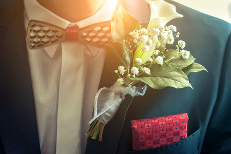 Wedding white flowers on the blue mans jacket with red accessory.の写真素材