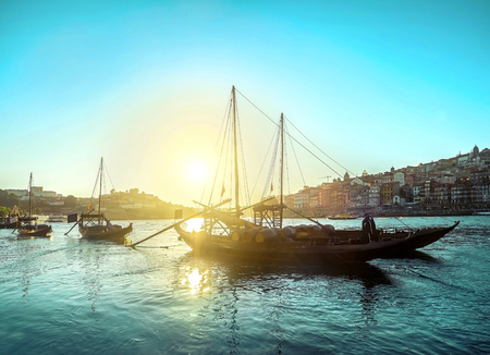 Historical boats with wine wooden casks on the river. Beautiful cityscape view in summer sunny day.の写真素材