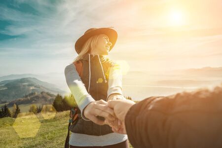 Happy traveler woman tourist stay on the green grass on the peak of mountain and look on the nice...