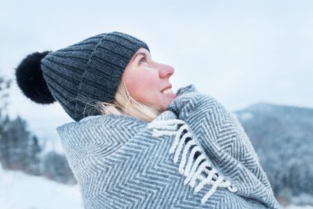 Happy woman traveler stay in snowy mountains and looking on nice winter weather, sunny day.