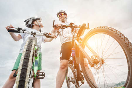 Father and son ride, cycling their bikes together, on sunny day, Happy family in helmets is riding bikes having fun.の写真素材