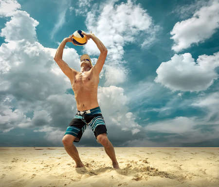 Beach volleyball player in action at sunny day under blue sky.の写真素材