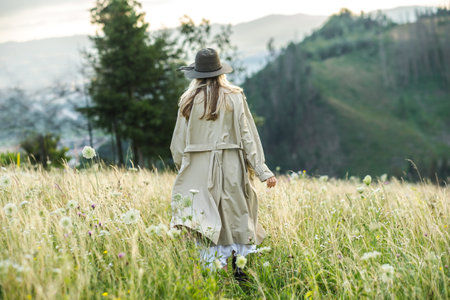 Portrait happy woman enjoying sunset stay on the green grass on the forest peak of mountain. Fresh air, Travel, Summer, Fall, Holidays, Journey, Trip, Lifestyle.の写真素材