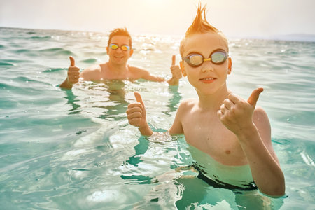 Happy family in swimming goggles, father and son bonding, play, swim in the sea looking at view enjoying summer vacation. Togetherness Friendly conceptの写真素材