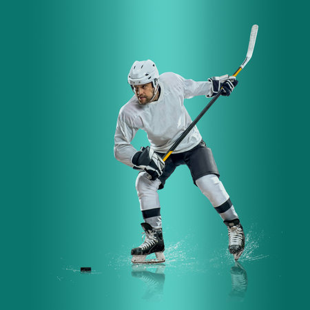 Professional ice hockey player hitting puck for winning goal in action on gradient multicolored neon background. Concept of sport competition.の写真素材