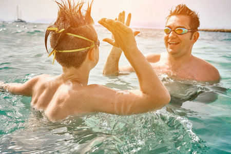 Happy family, father and son bonding, swim in the sea looking at view enjoying summer vacation. Togetherness Friendly conceptの写真素材