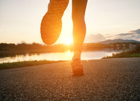Woman runs in the park on autumn morning. Healthy lifestyle concept, people go in sports outdoors. Silhouette family at sunset. Fresh air. Health care, authenticity, sense of balance and calmness.の写真素材