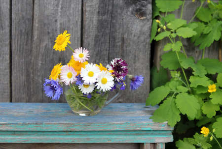 Bouquet of wildflowers in a glass cup. Chamomile, cornflower and daisy are widely used in folk medicine.の写真素材
